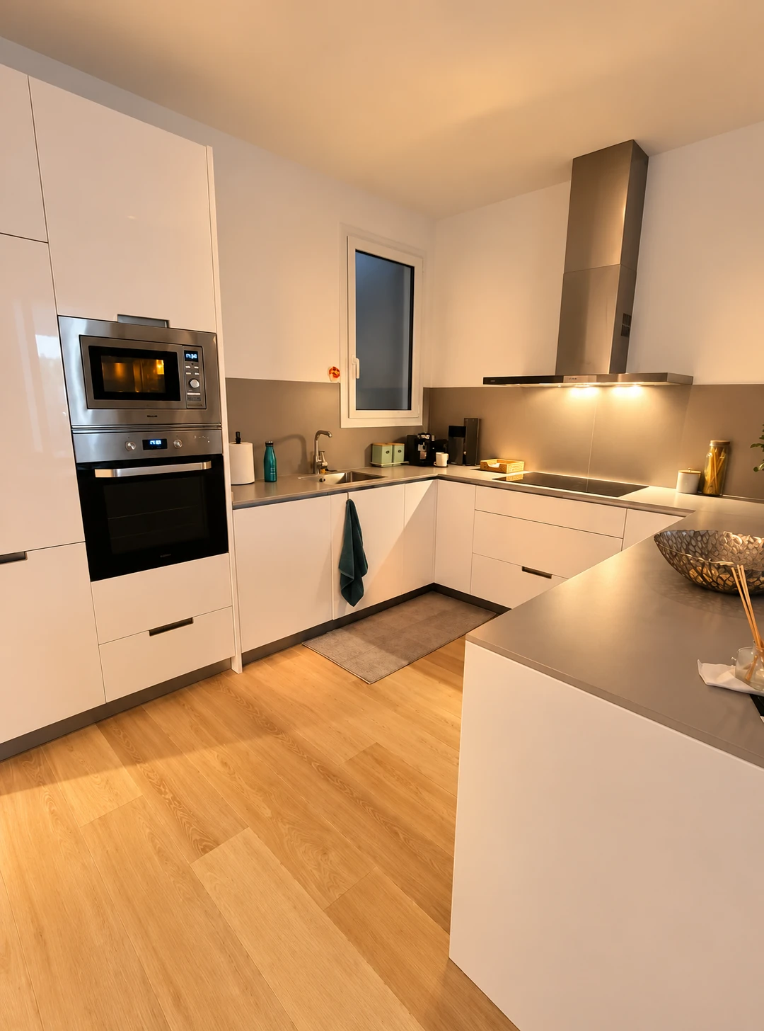 Cocina abierta con muebles claros e iluminación cálida